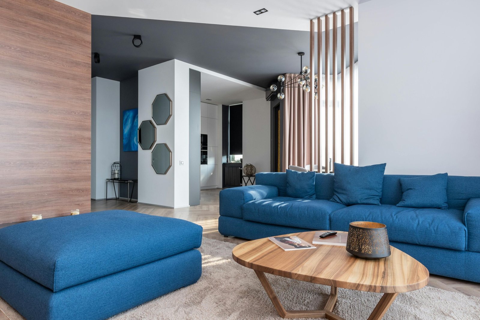 Spacious and stylish modern living room featuring a blue sofa set and contemporary decor.