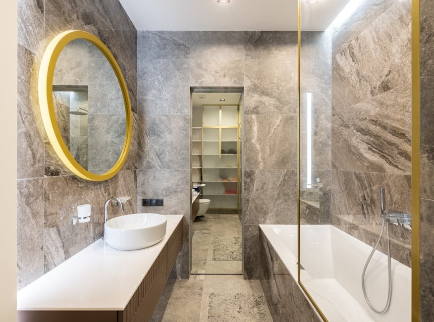 Elegant modern bathroom featuring marble walls, gold accents, and sleek fixtures for a luxurious feel.